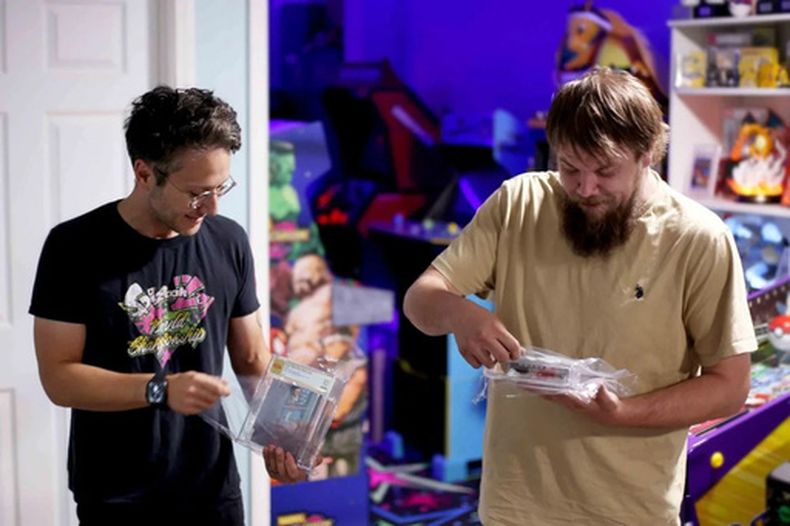 En esta fotografía facilitada por Nintendo Wire, el editor Jason Ganos, izquierda, y el propietario de la tienda OneStopWonders, Kevin Braun, sostienen copias de los videojuegos *Super Mario Bros.* y *Duck Hunt* —certificadas por PSA— el miércoles 17 de junio de 2026; ambos ejemplares fueron redescubiertos en un almacén de Waukesha, Wisconsin. (Lauren Ganos/Nintendo Wire via AP)