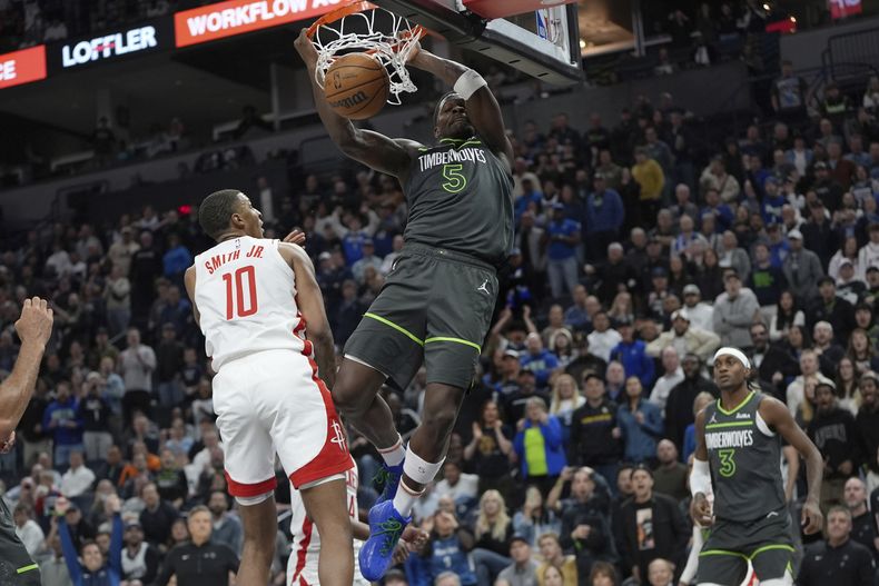 Anthony Edwards, de los Timberwolves de Minnesota, realiza una clavada frente a Jabari Smith Jr., de los Rockets de Houston, el martes 2 de abril de 2024 (AP Foto/Abbie Parr)