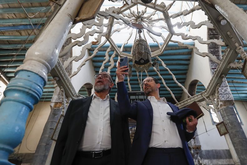 El rabino Yusuf Hamra, izquierda, y su hijo Henry toman fotografías en su visita a la sinagoga al-Raqi en la antigua ciudad de Damasco, el 18 de febrero de 2025. (AP Foto/Omar Sanadiki)