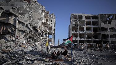 americateve | El palestino Ziad Rizk, de 38 a&ntilde;os, aparece sentado con otros en un peque&ntilde;o refugio junto a las destruidas torres Nada, en el pueblo de Beit Lahiya, en el norte de la Franja de Gaza, el lunes, 11 de agosto de 2014. (AP Photo/Khalil Hamra)