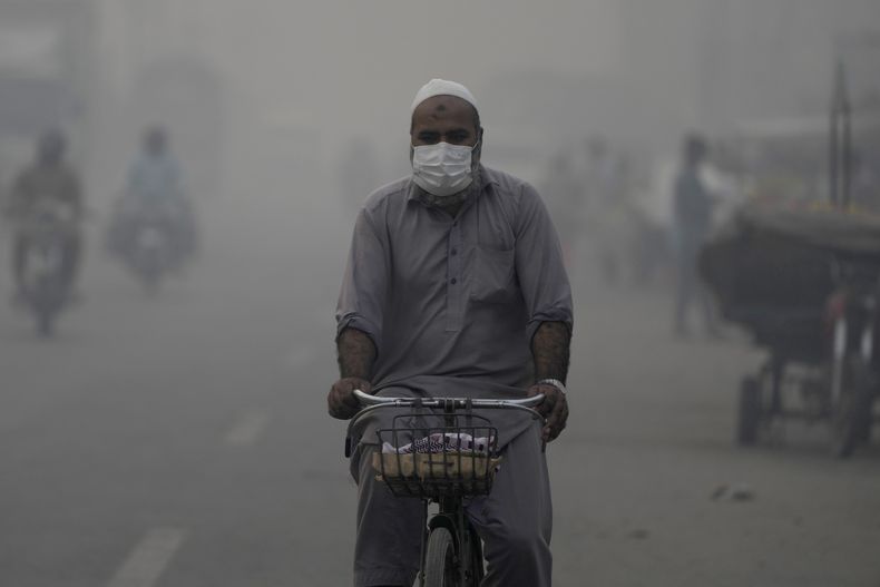 Un ciclista con mascarilla se dirige a su lugar de trabajo en medio del smog en Lahore, Pakistán, el miércoles 6 de noviembre de 2024. (AP Foto/K.M. Chaudary)