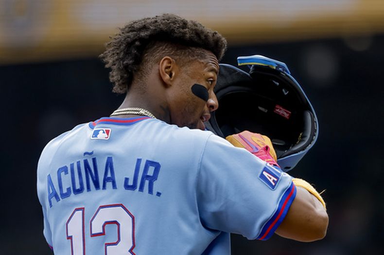 Ronald Acuña Jr., de los Bravos de Atlanta, se acomoda el casco mientras está parado en la tercera base contra los Piratas de Pittsburgh durante la primera entrada de un partido de béisbol, el sábado 6 de junio de 2026, en Atlanta. (Foto AP/Erik S. Lesser)