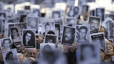 ARCHIVO - Personas sostienen fotografías de víctimas mientras suenan las sirenas durante una ceremonia que marca el 30 aniversario del bombardeo del centro judío AMIA que mató a 85 personas en Buenos Aires, Argentina, el 18 de julio de 2024. (AP Foto/Natacha Pisarenko, Archivo)