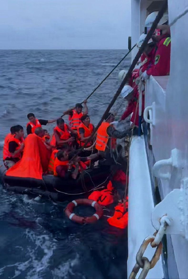 En esta imagen publicada por la agencia de noticias Xinhua, tripulantes del Nanhai Jiu 115, un barco de rescate operado por la Oficina de Rescate de Nanhai del Ministerio chino de Transporte, recoge a tripulantes del barco vietnamita Khoi Nguyen de una lancha salvavidas en el mar de China Meridional, el 25 de julio de 2026. (Sansha Maritime Safety Administration//Xinhua via AP)