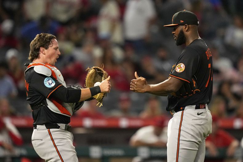 Adley Rutschman, izquierda, y el relevista Félix Bautista, de los Orioles de Baltimore, se felicitan mutuamente después de que su equipo derrotara en juego de béibsol de Grandes Ligas a Los Angelilos de Los Ángeles el viernes 9 de mayo de 2025, en Anaheim, California. (AP Foto/Mark J. Terrill)