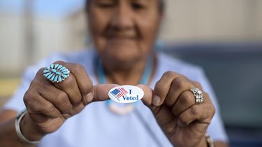 Mildred James, de Sanders, Arizona, muestra su calcomanía de Yo voté mientras espera que se revelen los resultados de las elecciones primarias presidenciales de la Nación Navajo en Window Rock, Arizona, el 28 de agosto de 2018. (AP Foto/Cayla Nimmo, Archivo)
