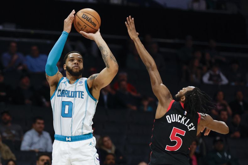 Miles Bridges, de los Hornets de Charlotte, dispara frente a Immanuel Quickley, de los Raptors de Toronto, en el encuentro del miércoles 7 de febrero de 2024 (AP Foto/Nell Redmond)