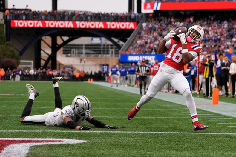 El receptor abierto de los Patriots de Nueva Inglaterra, Kyle Williams (18), atrapa un pase de touchdown ante el esquinero de los Raiders de Las Vegas, Hezekiah Masses (35), durante un partido de fútbol americano de la NFL en Foxborough, Massachusetts, el domingo 11 de octubre de 2026. (Foto AP/Charles Krupa)