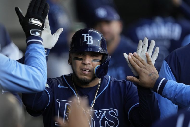 El mexicano Isaac Paredes, de los Rays de Tampa Bay, celebra en la caseta tras anotar en un doble de Luke Raley ante los Medias Blancas de Chicago, el jueves 27 de abril de 2023 (AP Foto/Charles Rex Arbogast)