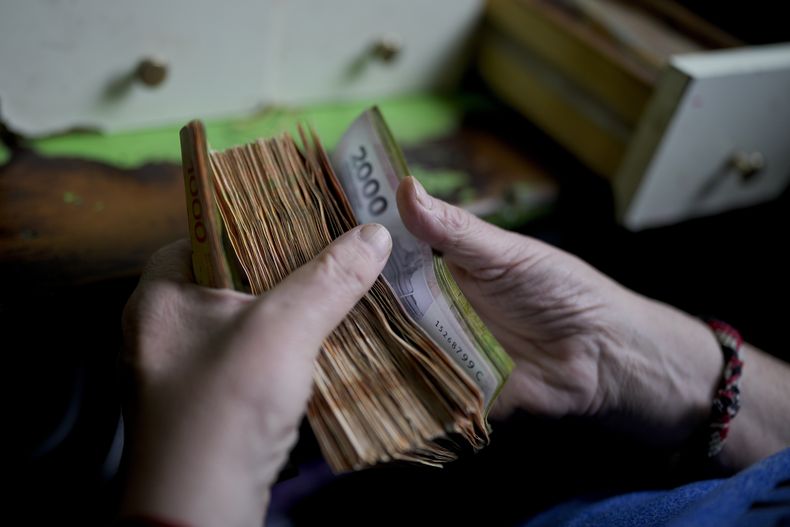 Archivo - Un trabajador cuenta el dinero en una tienda de abarrotes en Buenos Aires, Argentina, 21 de noviembre de 2023. (AP Foto/Natacha Pisarenko, Archivo)
