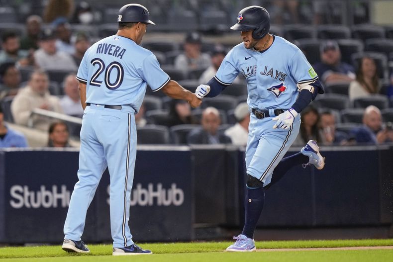 George Springer de los Azulejos de Toronto celebra con el entrenador de tercera base Luis Rivera (20) mientras recorre las bases luego de conectar un cuadrangular durante el juego ante los Yanquis de Nueva York. Martes 19 de septiembre de 2023, en Nueva York. (AP Foto/Bryan Woolston)