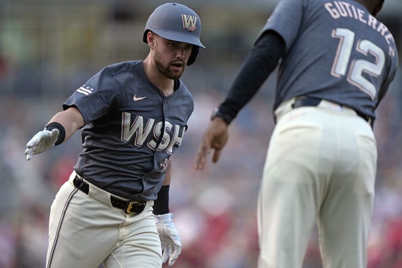 Lane Thomas, de los Nacionales de Washington, es felicitado por el coach de la antesala Ricky Gutiérrez, tras conectar un jonrón en el juego ante los Marlins de Miami, el viernes 14 de junio de 2024 (AP Foto/Susan Walsh)