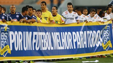 americateve | En esta fotograf&iacute;a del 14 de noviembre de 2013, jugadores de los equipos de f&uacute;tbol Santos y Bah&iacute;a sostienen una pancarta que dice "Por un mejor f&uacute;tbol para todos" durante un encuentro del campeonato brasile&ntilde;o e