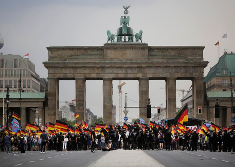 ARCHIVO - Partidarios de Alternativa por Alemania (AfD) ondean banderas de su partido y de Alemania durante una marcha ante la puerta de Brandeburgo en Berlín, Alemania, el 27 de mayo de 2018. (AP Foto/Markus Schreiber, Archivo)
