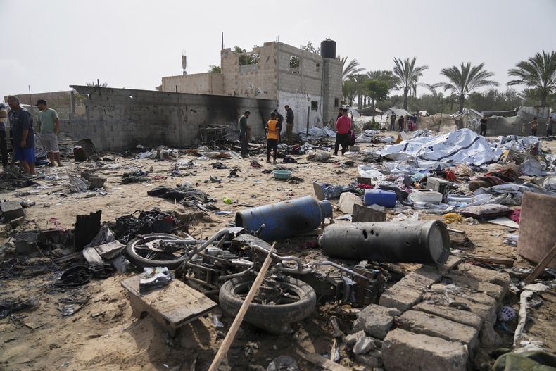 Palestinos revisan una zona destruida por ataques aéreos israelíes en Jan Yunis, en la Franja de Gaza, el domingo 18 de mayo de 2025. (AP Foto/Abdel Kareem Hana)
