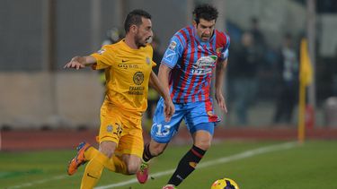 americateve | Mariano Izco, del Catania, conduce el bal&oacute;n, marcado por Alessandro Agostini, del Verona, durante el partido de la Serie A italiana disputado el s&aacute;bado 14 de diciembre de 2013 (AP Foto/Carmelo Imbesi)