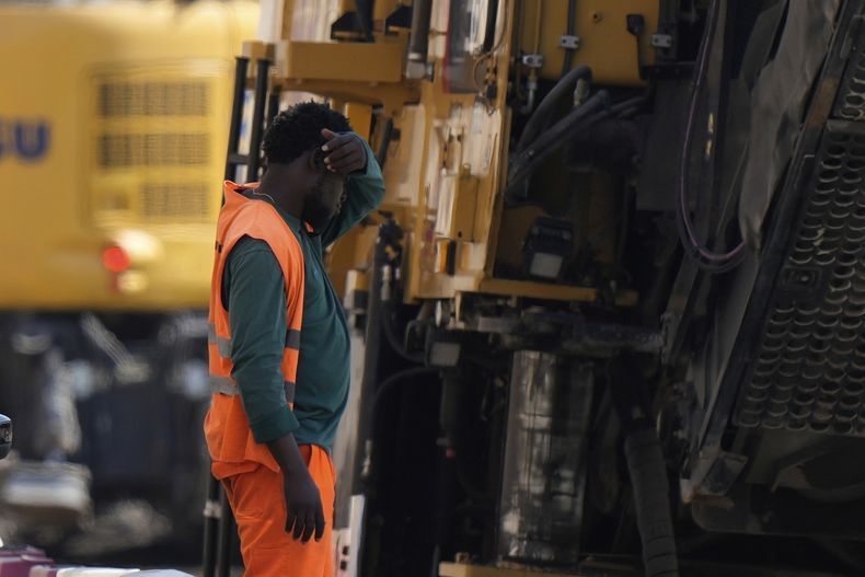 ARCHIVO - Un trabajador se toma un descanso en las obras de construcción de una carretera, en Milán, Italia, el 1 de julio de 2025. (AP Foto/Luca Bruno, archivo)