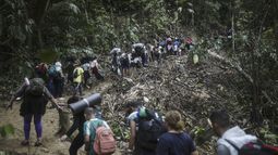 ARCHIVO - Migrantes avanzan por el Tapón del Darién desde Colombia a Panamá en su larga y compleja ruta para llegar hasta Estados Unidos, el 9 de mayo de 2023. Colombia y Panamá están fallando en dar protección a los miles de migrantes que cruzan la peligrosa jungla del Darién, como paso previo para avanzar hasta Estados Unidos, y que están más expuestos a los asaltos y la violencia sexual, de acuerdo con un informe de la organización Human Rights Watch publicado el 3 de abril de 2024. (AP Foto/Iván Valencia, Archivo)