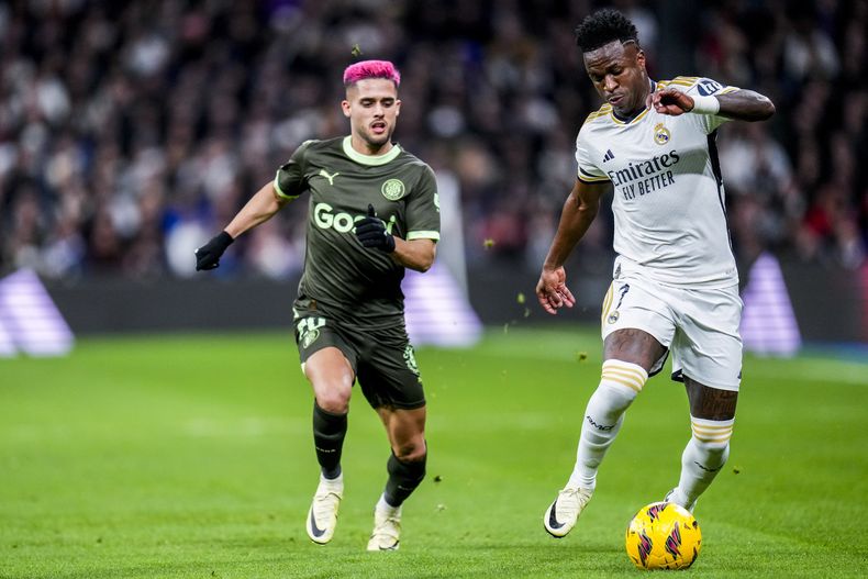 ARCHIVO - El brasileño Yan Couto (izquierda), del Girona, marca a su compatriota Vinicius Junior, del Real Madrid, durante un partido de La Liga española, el sábado 10 de febrero de 2204 (AP Foto/Manu Fernandez, archivo)