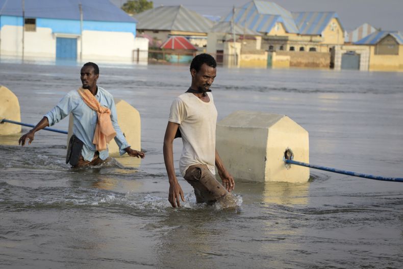 Hombres caminando en una calle inundada en la ciudad de Beledweyne, Somalia, el lunes 15 de mayo de 2023. La Oficina de Naciones Unidas para la Coordinación de Asuntos Humanitarios estima que 460.000 personas se han visto afectadas por las inundaciones causadas por las lluvias desde mediados de marzo. (AP Foto)