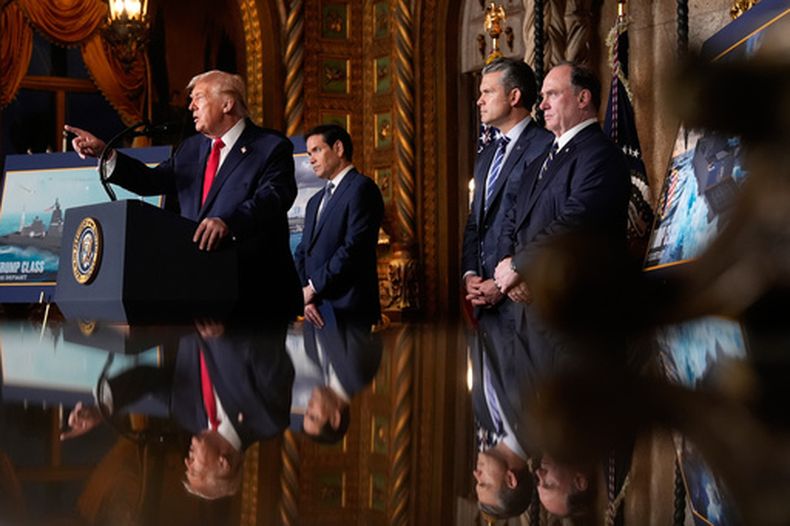 El presidente Donald Trump habla acompañado por --de izquierda a derecha-- el secretario de Estado, Marco Rubio; el secretario de Defensa, Pete Hegseth, y el secretario de la Armada, John Phelan, en su club Mar-a-Lago, el lunes 22 de diciembre de 2025, en Palm Beach, Florida. (AP Foto/Alex Brandon)