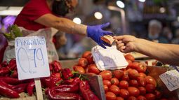 ARCHIVO - Un cliente paga verduras en el mercado Maravillas, Madrid, 12 de mayo de 2022. La economía europea logró un escaso crecimiento del 0,1% en los primeros tres meses del año, evitando por poco una recesión invernal en medio de la inflación que corroe la disposoción de la gente a gastar. (AP Foto/Manu Fernandez, File)
