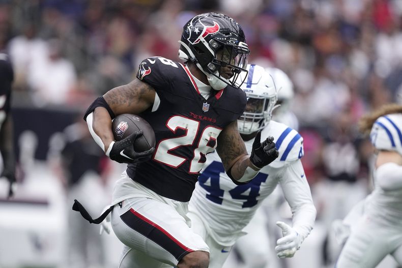 El corredor de los Texans de Houston Joe Mixon corre con el balón frente al linebacker de los Colts de Indianápolis Zaire Frankin en el encuentro del domingo 27 de octubre del 2024. (AP Foto/Tony Gutierrez)