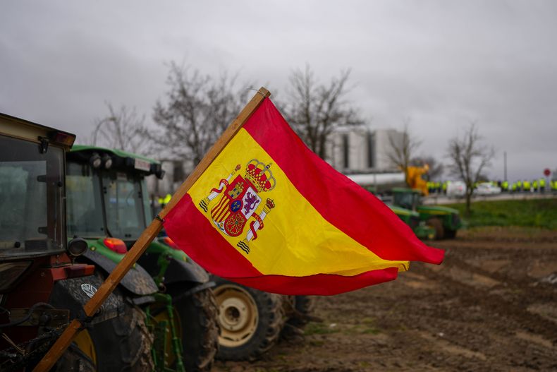 Una bandera de España, colgada de un tractor estacionado en Corral de Almaguer, cerca de Toledo, en el centro de España, el 9 de febrero de 2024. (AP Foto/Manu Fernandez)