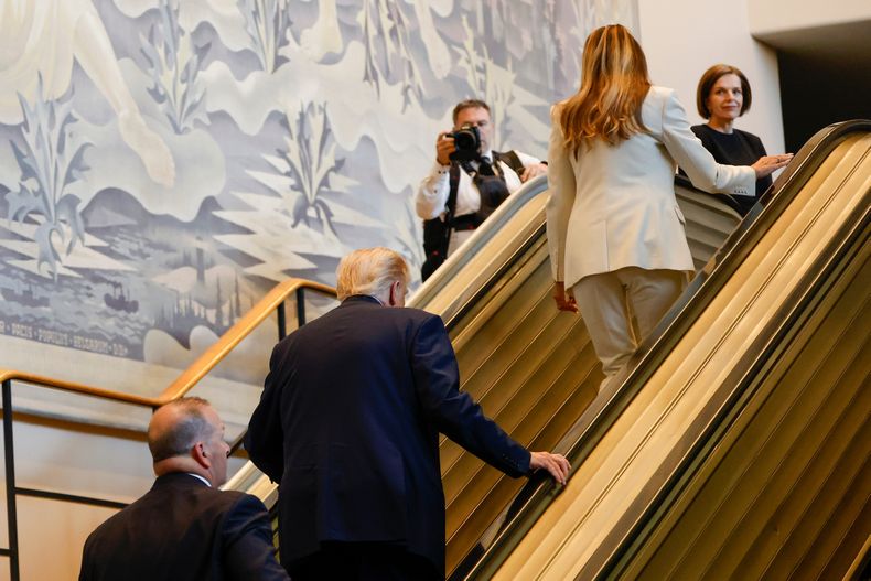 El presidente de Estados Unidos, Donald Trump, en el centro, y la primera dama Melania Trump, arriba a la derecha, suben por la escalera mecánica después de que esta se detuviera mientras se dirigían al Salón de la Asamblea General, en la sede de la ONU, el martes 23 de septiembre de 2025. (AP Foto/Stefan Jeremiah)