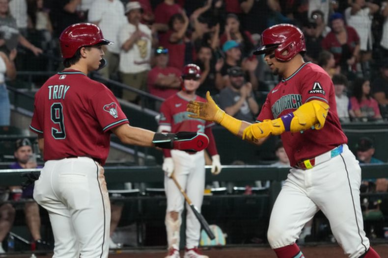 Gabriel Moreno, derecha, de los Diamondbacks de Arizona, celebra con Tommy Troy (9) después de batear un cuadrangular de dos carreras contra los Nacionales de Washington en la quinta entrada del juego de béisbol de Grandes Ligas, el domingo 7 de junio de 2026, en Phoenix. (AP Foto/Rick Scuteri)