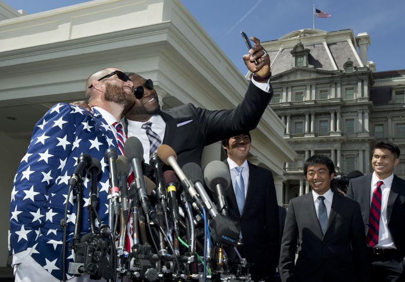 El jugador dominicano de los Medias Rojas, David Ortiz, centro, se toma un selfie con su compa&ntilde;ero Johnny Gomes a las afueras de la Casa Blanca el martes, 1 de abril de 2014, tras una ceremonia con el presidente Barack Obama. (AP Photo/Manuel Balce