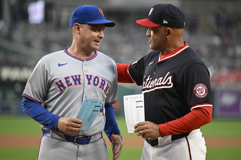 Carlos Mendoza, mánager de los Mets de Nueva York, y Miguel Cairo, su contraparte de los Nacionales de Washington, previo a un juego, el martes 19 de agosto de 2025, en Washington. (AP Foto/John McDonnell)