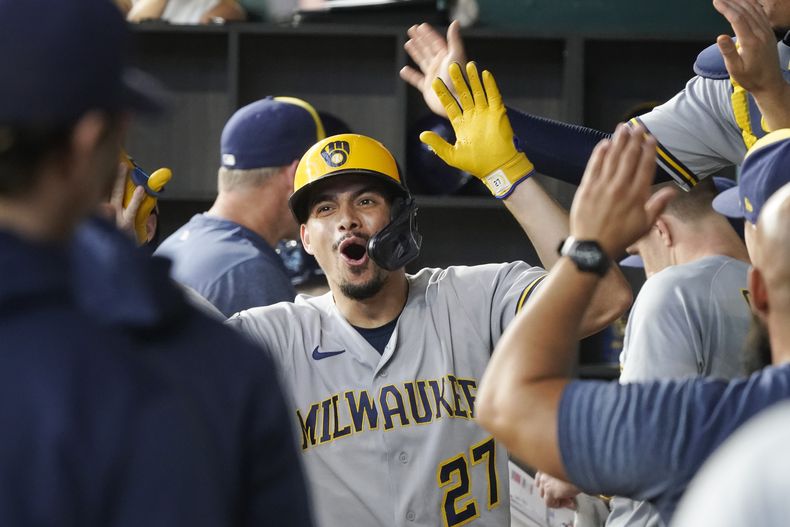 El dominicano Willy Adames, de los Cerveceros de Milwaukee, festeja en el dugout con sus compañeros, tras batear un jonrón solitario durante el juego del sábado 19 de agosto de 2023, ante los Rangers de Texas (AP Foto/LM Otero)
