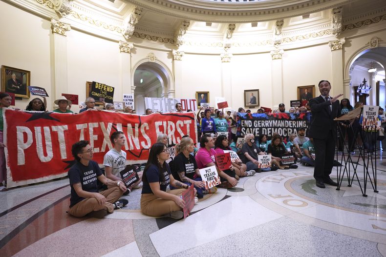 El legislador Joaquin Castro, derecha, habla con manifestantes reunidos en la rotonda frente a la Cámara de Representantes en el Capitolio de Texas, en un momento en que los legisladores debaten la reconfiguración del mapa parlamentario de Estados Unidos, el miércoles 20 de agosto de 2025, en Austin, Texas. (AP Foto/Eric Gay)