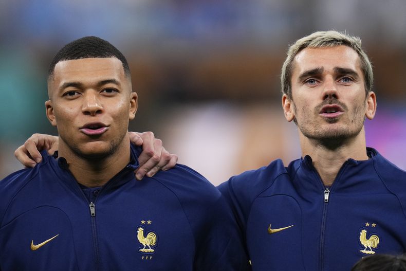 ARCHIVO - Los franceses Kylian Mbappé, a la izquierda, y Antoine Griezmann antes del partido final de la Copa del Mundo entre Argentina y Francia en el estadio Lusail en Lusail, Qatar, el domingo 18 de diciembre de 2022. (AP Foto/Manu Fernández, Archivo)