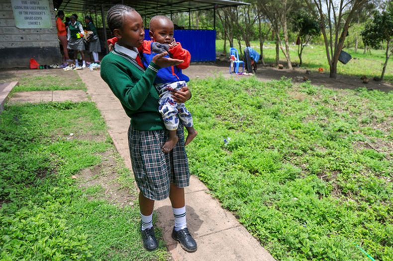 Valarie Wairimu, de 19 años, con su hijo, Kayden Darmain, durante el receso en la Escuela Femenina Greenland en Kiserian, Kajiado, Kenia, el 5 de marzo de 2026. (AP Foto/Andrew Kasuku)