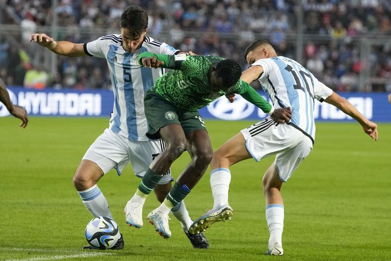 Salim Lawal de Nigeria, en el centro, disputa la pelota contra Federico Redondo, izquierda, y Valentín Carboni de Argentina durante el duelo por los octavos de final del Mundial Sub20 en el estadio Bicentenario de San Juan, Argentina, miércoles 31 mayo, 2023. (AP Foto/Natacha Pisarenko)
