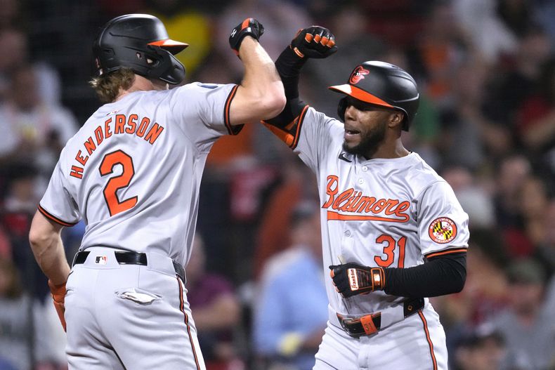 Cedric Mullins (derecha), de los Orioles de Baltimore, es felicitado por Gunnar Henderson luego de batear un jonrón de dos carreras ante los Medias Rojas de Boston, el martes 10 de septiembre de 2024 (AP Foto/Charles Krupa)