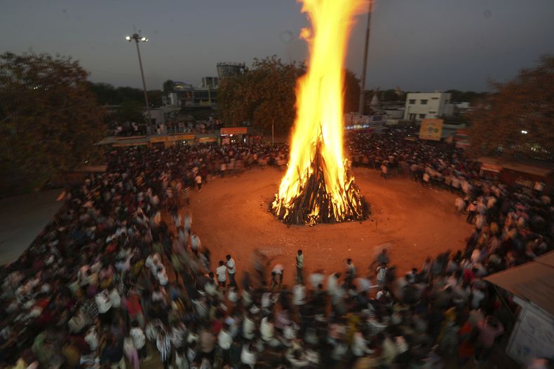 La gente practica rituales alrededor del fuego sagrado, llamado Holi ka dahan, durante la celebración del Holi en la localidad de Palaj, cerca de Gandhinagar, India, el 13 de marzo de 2025. (AP Foto/Ajit Solanki)