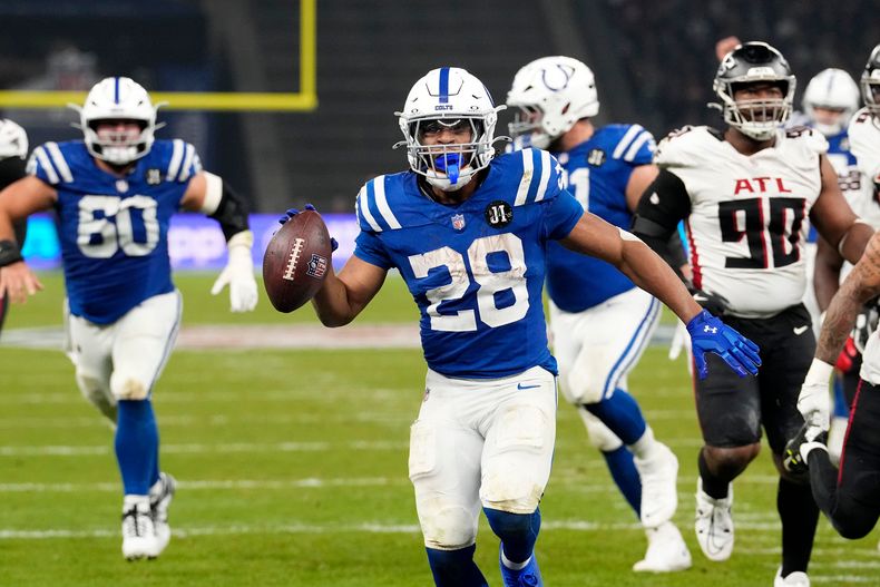 Jonathan Taylor (28), corredor de los Colts de Indianápolis, anota un touchdown durante el tiempo extra del partido de la NFL contra los Falcons de Atlanta, el domingo 9 de noviembre de 2025, en Barlín, Alemania. (AP Foto/Martin Meissner)