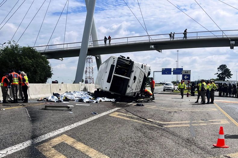 Efectivos de emergencias, junto a un bus que volcó en una autopista en Johannesburgo, Sudáfrica, el 11 de marzo de 2025. (AP Foto)