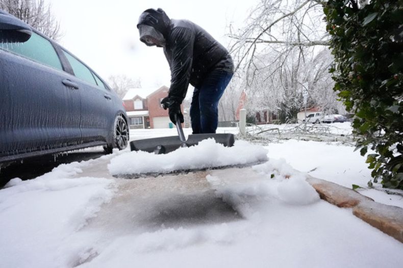 David Bentley remueve nieve frente a su cochera durante la tormenta invernal el domingo 25 de enero del 2026 en Nashville, Tennessee. (AP Foto/George Walker IV)