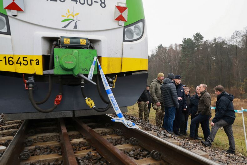 El primer ministro polaco Donald Tusk, segundo de derecha a izquierda, visita el lugar donde la línea férrea Mika resultó dañada por un sabotaje, cerca de Deblin, Polonia, el lunes 17 de noviembre de 2025. (Foto AP/KPRM)