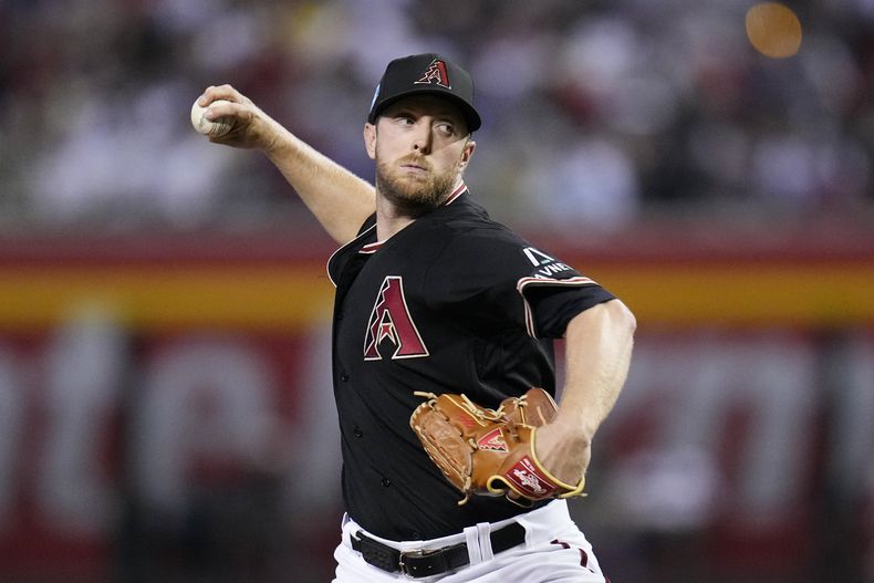 Merrill Kelly, abridor de los Diamondbacks de Arizona, lanza en contra de los Medias Rojas de Boston durante la primera entrada del juego de béisbol, el domingo 28 de mayo de 2023, en Phoenix. (AP Foto/Ross D. Franklin)