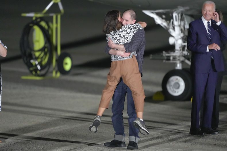 El periodista Evan Gershkovich abraza a su madre, Ella Milman, ante la mirada del presidente de Estados Unidos, Joe Biden (derecha), en la Base Andrews de la Fuerza Aérea, en Maryland, tras su liberación como parte de un canje con Rusia, el 1 de agosto de 2024. (AP Foto/Manuel Balce Ceneta)