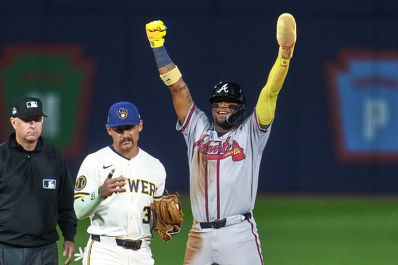 Ronald Acuña Jr., derecha, de los Bravos de Atlanta, celebra a un costado de Joey Ortiz (3), de los Cerveceros de Milwaukee, después de robarse segunda base durante la quinta entrada del juego de béisbol de Grandes Ligas, el domingo 23 de agosto de 2026, en Williamsport, Pensilvania. (AP Foto/Gene J. Puskar)
