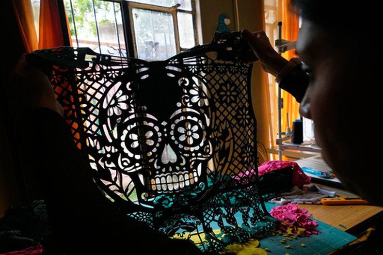 Cande Martínez prepara camisetas de fútbol, inspiradas en el papel picado, de la marca Mexclart, en Cuautitlán Izcalli, México, el lunes 25 de mayo de 2026. (AP Foto/Marco Ugarte)