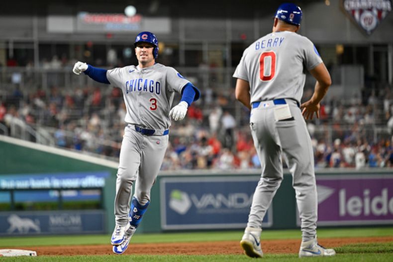 Alex Bregman, de los Cachorros de Chicago, es felicitado por el coach de la antesala Quintin Berry tras batear un jonrón de dos carreras ante los Nacionales de Washington, el miércoles 12 de agosto de 2026 (AP Foto/John McDonnell)