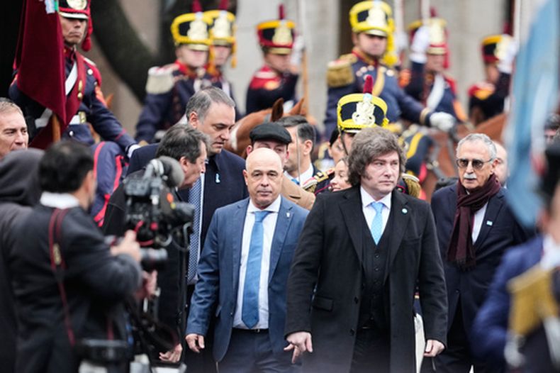 El presidente argentino Javier Milei llega a la catedral para asistir a un Te Deum con motivo del aniversario de la Revolución de Mayo mientras detrás a la izquierda sobresale la figura de su jefe de Ganinete, Manuel Adorni, en Buenos Aires, Argentina, el lunes 25 de mayo de 2026. (Foto AP/Natacha Pisarenko)