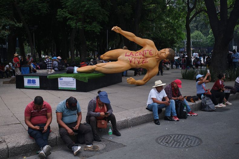 Una estatua del Mundial, con un grafiti que dice en español La CNTE vive, en referencia a la Coordinadora Nacional de Trabajadores de la Educación, yace de lado durante una protesta de maestros por mejores salarios en Ciudad de México, el martes 2 de junio de 2026. (Foto AP/Jon Orbach)
